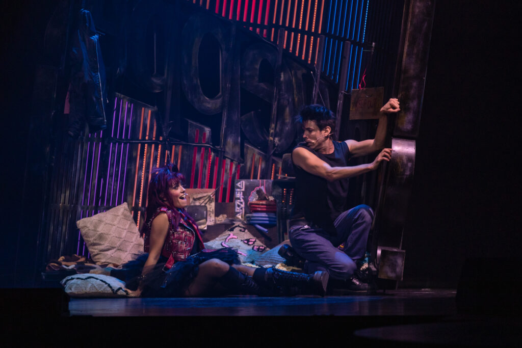 Escena dramática con dos actores interactuando en el escenario